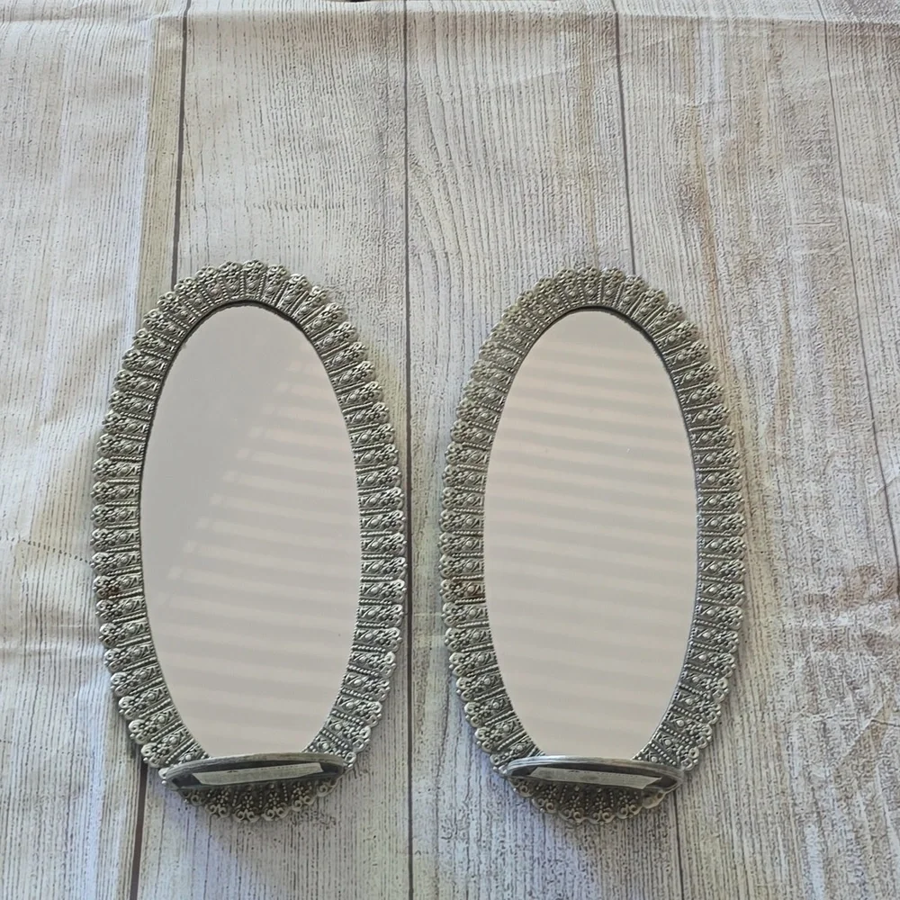 Set of 2 new silver, oval shaped ornate mirror sconces.